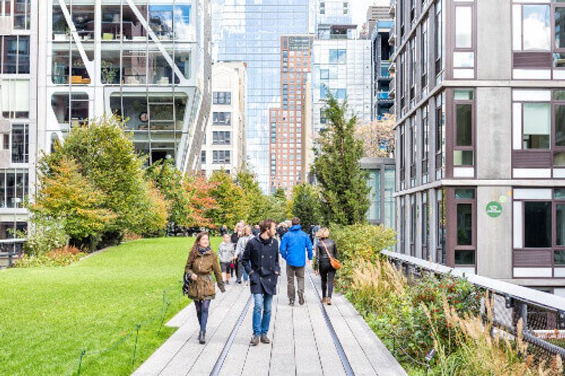 The High Line park boardwalk, an urban garden with many tourists exploring.