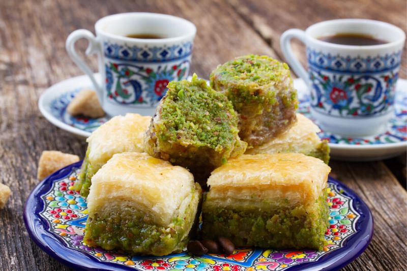 urkish delights and baklava sweets with Turkish coffee cups on a table.