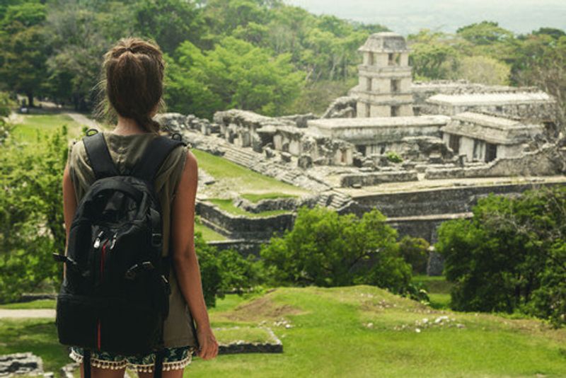 A woman looks down at the ruins.