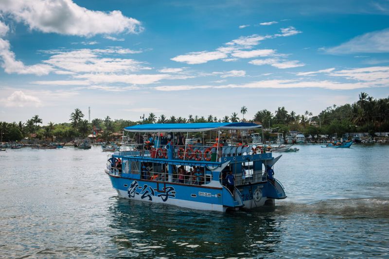 A tourist boat taking a group tour out into the ocean to see blue whales in Sri Lanka