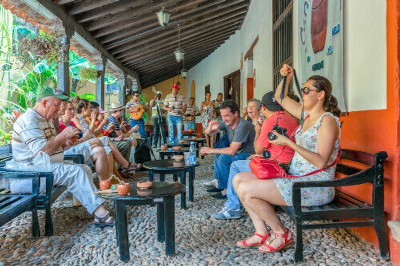 Tourists drinking Canchanchara in La Canchanchara, in the Unesco World Heritage village of Trinidad, Cuba.