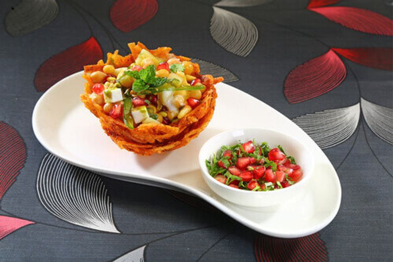 Basket Chaat or Potato Basket stuffed with potato sprouts served with curd and chutney in Lucknow, India.