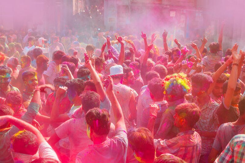 People covered with colorful paint for Holi festival in Udaipur.