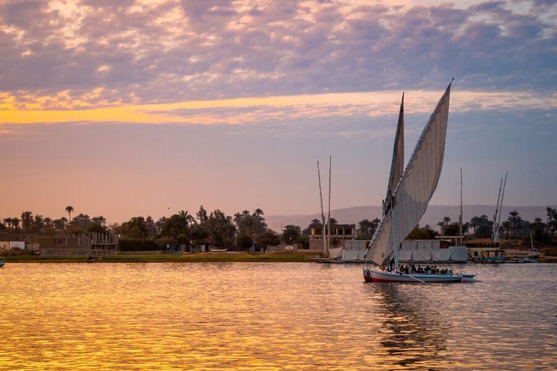 Felucca sailboat with tourists during a sunset in the Nile River