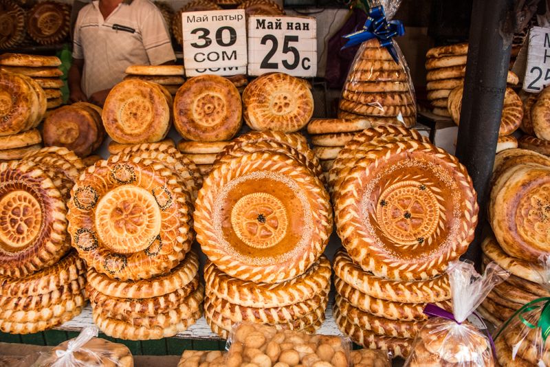 Fresh tandyr nan bread stacked high in Bishkek, a staple of everyday Kyrgyz cuisine.