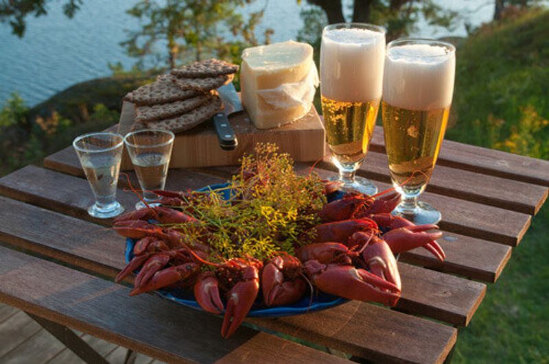 Table set for a traditional swedish crayfish party with beer on a mid summer afternoon.