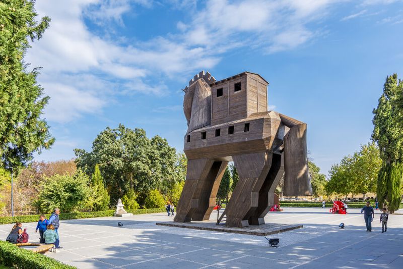 A group of tourists taking photos of the replica of the Trojan Horse.