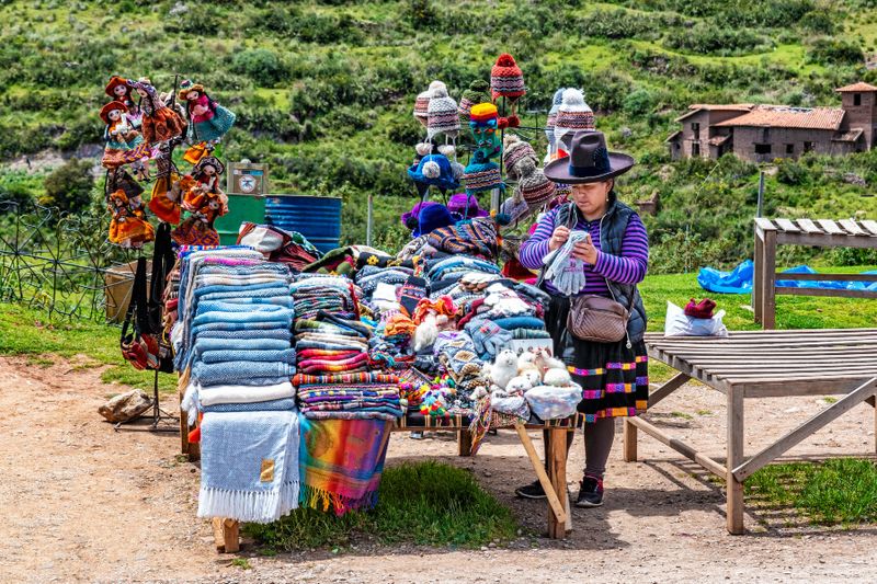 Peruvian woman selling traditional clothes and knitted products made from Alpaca wool.