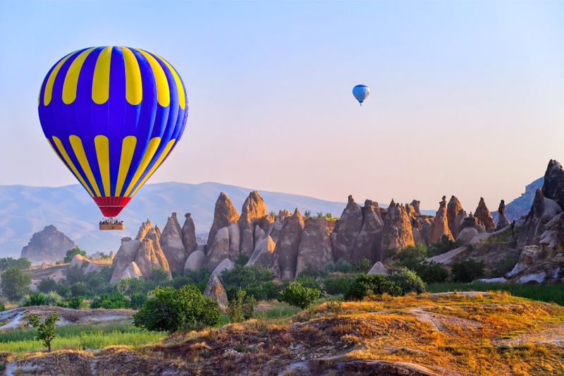 Hot air balloons flying over the rocky landscape of Cappadocia