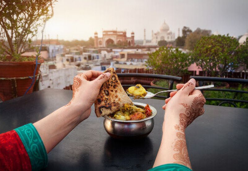 Visitors can enjoy traditional Indian food in rooftop restaurants with views of the Taj Mahal.