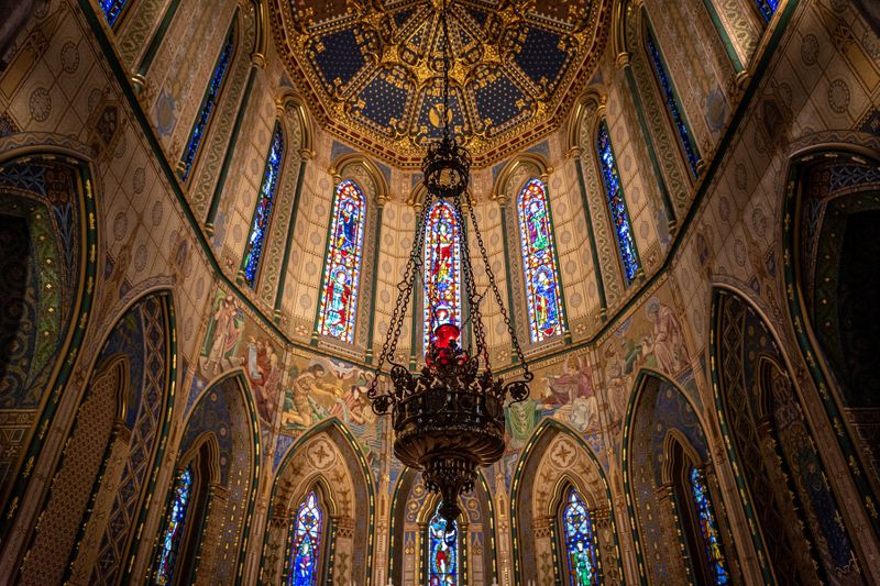 Magnificient interior of St. Mary's Cathedral with stained glass windows and roof decorated with biblical themes.