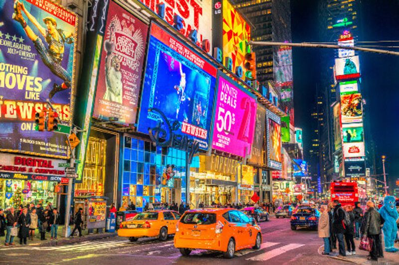 Broadway shows with neon lights in the busy streets of Times Square.