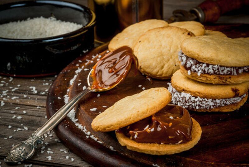 Traditional dessert shortbread cookies served with dulce de leche and coconut in Argentina.