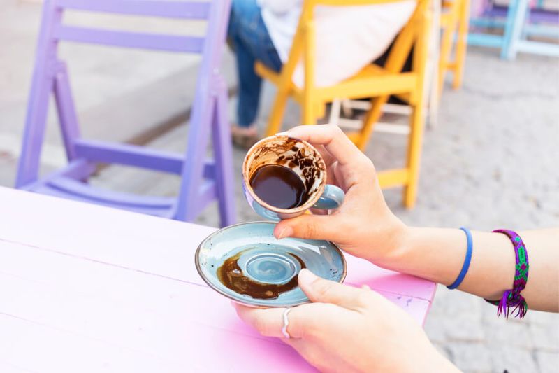 A woman trying Tasseography, or the art of fortune telling using coffee.