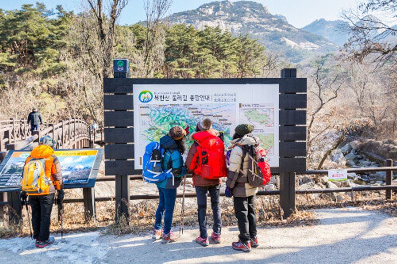 Korean hikers reading the road sign on the Bukhansan Mountain National Park in Seoul, South Korea.