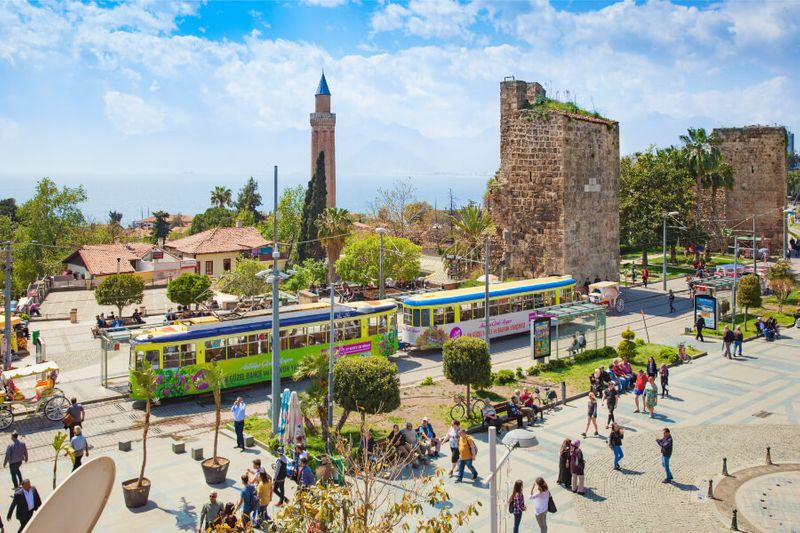 People walking near the clock tower, Tekeli Mehmet Pasa Mosque and Yivli Minare Mosque in Kaleici