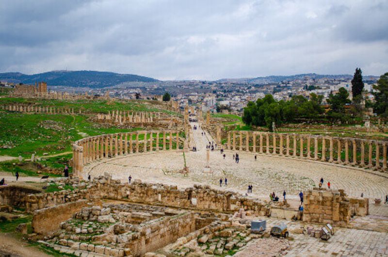Oval plaza with visitors visible in the Roma city of Jerash.