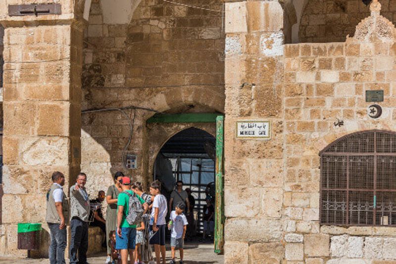 Tourists at the Gate of the Moors or Mughrabi Gate next to the Al-Aqsa mosque, located on the Temple Mount in Jerusalem, Israel.