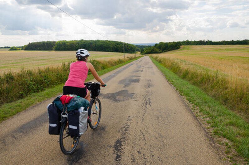 A biker with panniers cycles near Noyers.