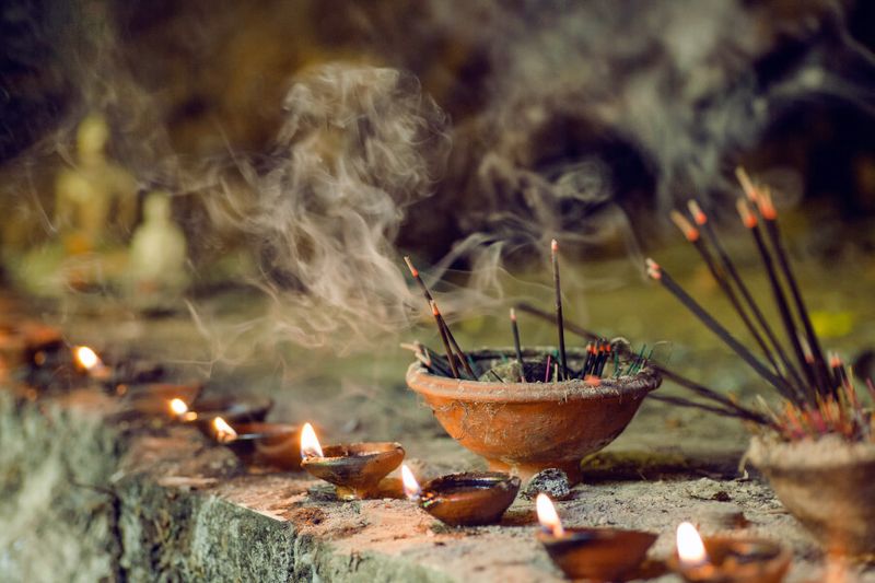 Burning aromatic incense sticks inside a temple in Sri Lanka