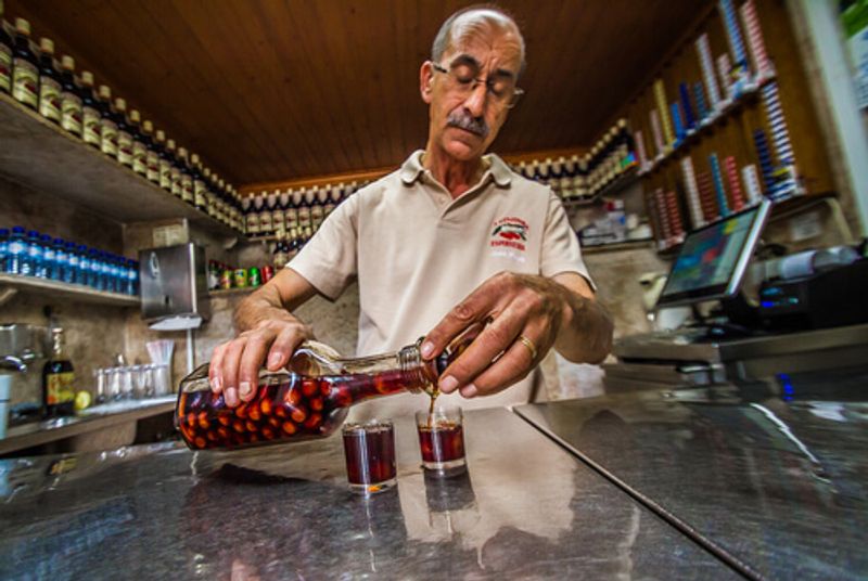 A local man pours Ginja liquor, Portugal.