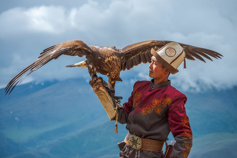 A Kyrgyz hunter showcasing the bond with his golden eagle