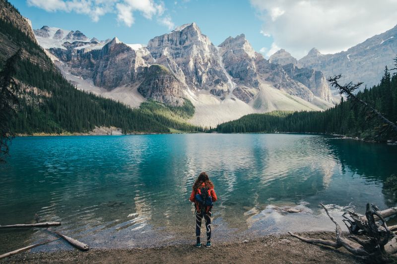 A woman stands on the banks of the Moraine Lake in the Banff National Park.