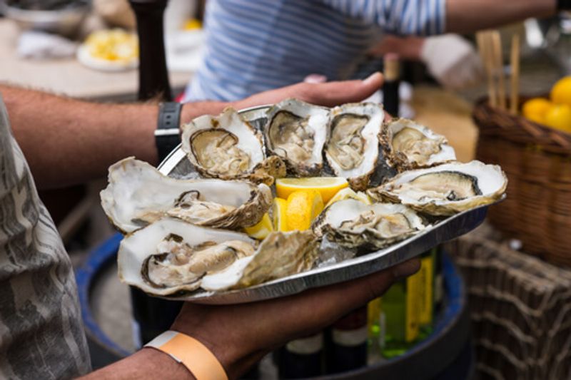 Delicious fresh oysters are enjoyed by tourists in South Africa.