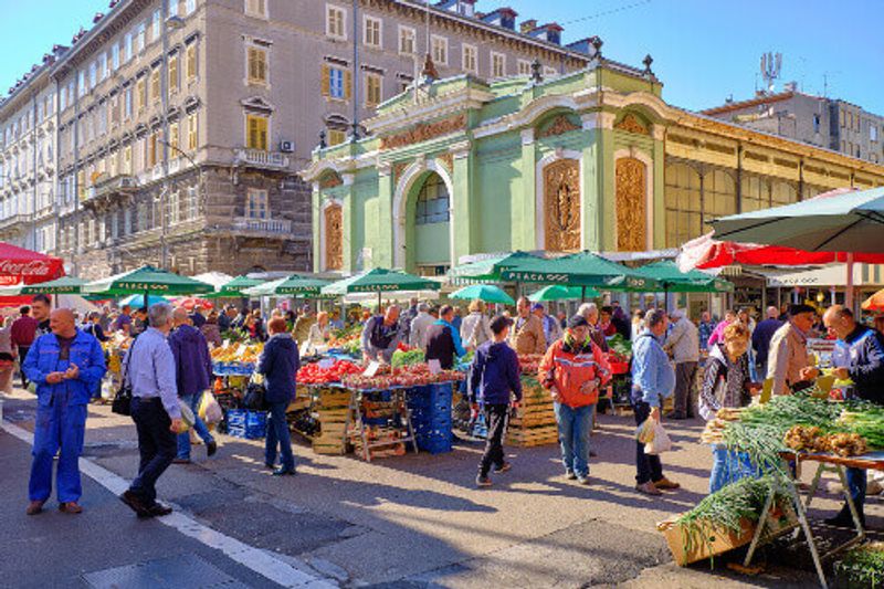 Customers walking around the central city market with fruit, vegetable and flower stalls in Rijeka.