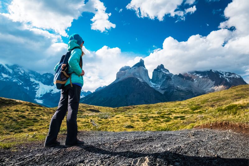 A female hiker on the trail in overlooking the Cuernos del Paine mountain range