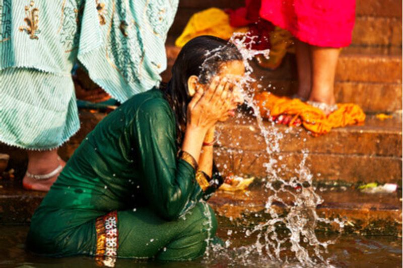 A local woman washes her face in the Ganges River.