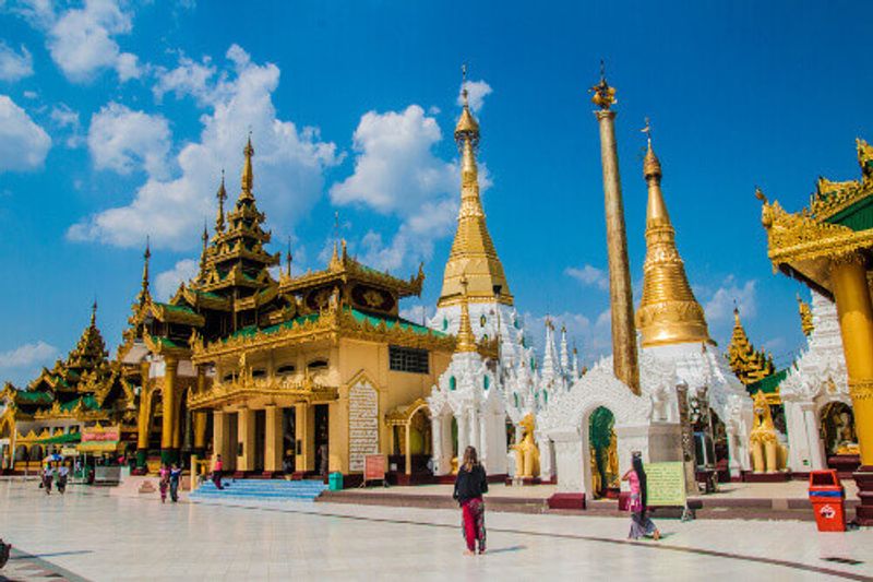The Schwedagon Pagoda with tourists and locals walking barefoot in Yangon.