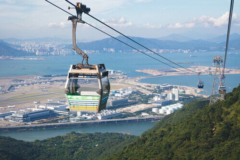 Ngong Ping cable cars with Chek Lap Kok Airport in the background.