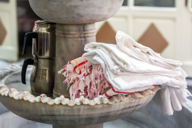 A Turkish traditional hammam with peshtemal towels and a marble fountain.