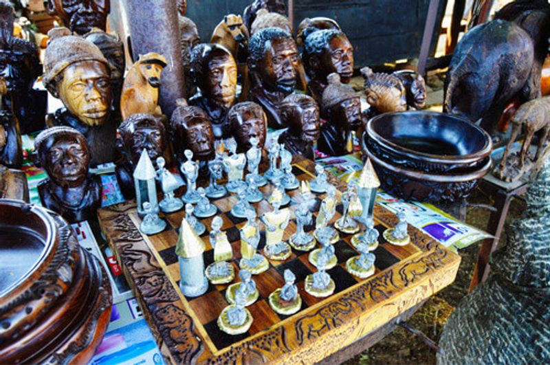 An African made chess board with souvenirs in the background.