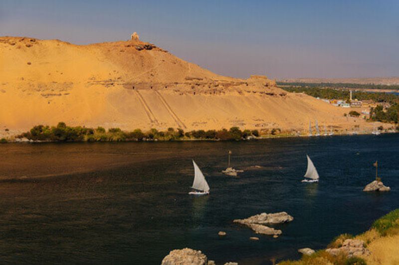 Feluccas sailing on the Nile River in Aswan, Egypt.