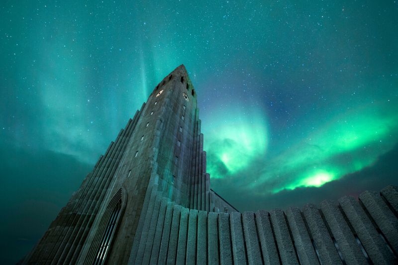 The Lutheran Church of Hallgrimskirkja with the greenish aurora borealis at night.