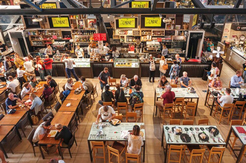 People having breakfast at a popular food court inside the Mercato Centrale City Market.