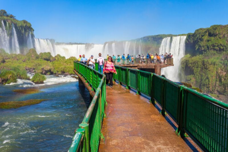 Tourists cross a bridge over the stunning natural wonder that is the Iguazu Falls.