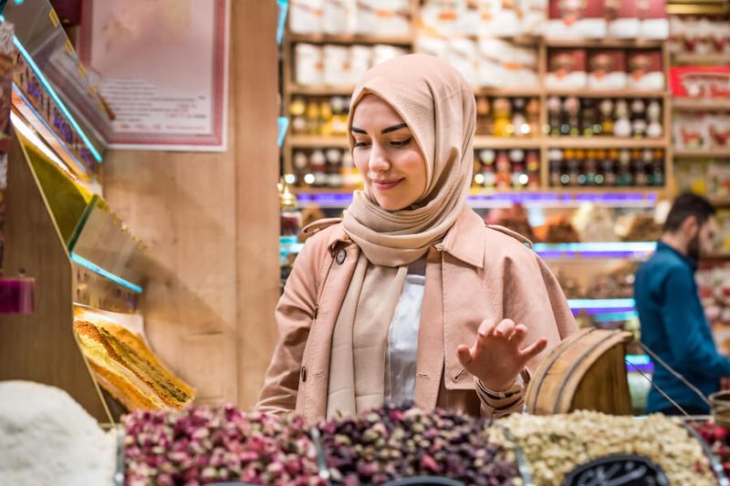 A woman dressed conservatively shopping at an Egyptian Bazaar.