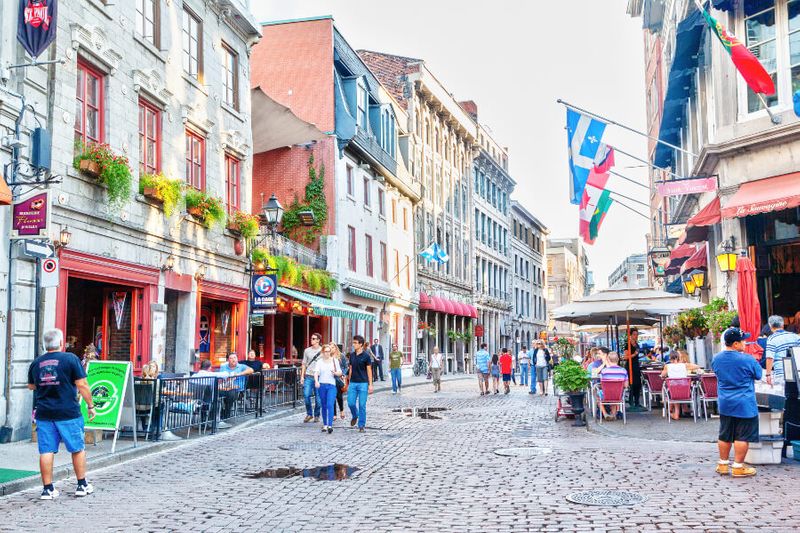 People explore the junction of Rue Saint-Paul and Rue Saint-Vincent, the oldest streets in Montreal.