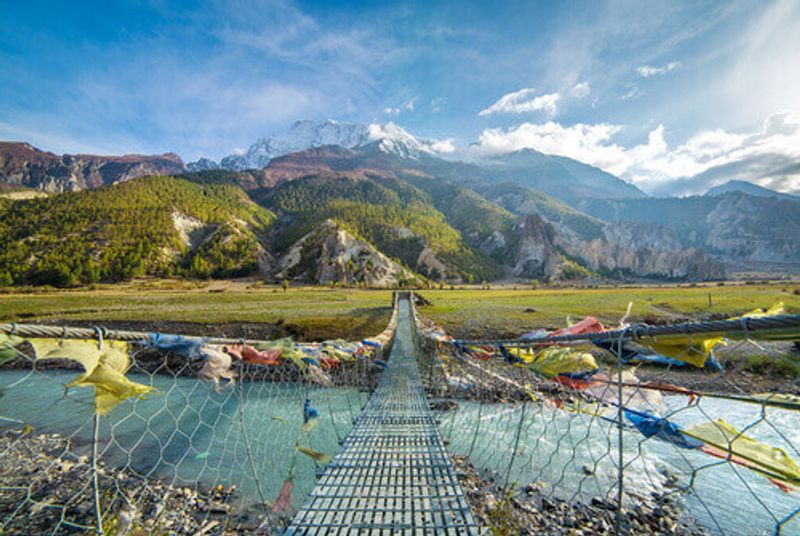 The Suspension bridge with buddhist prayer flags on the Annapurna Circuit Trek in Nepal.