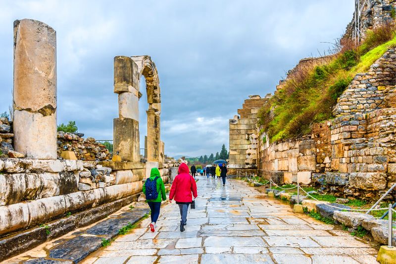Tourists wearing raincoats on a rainy day in the ancient city of Ephesus