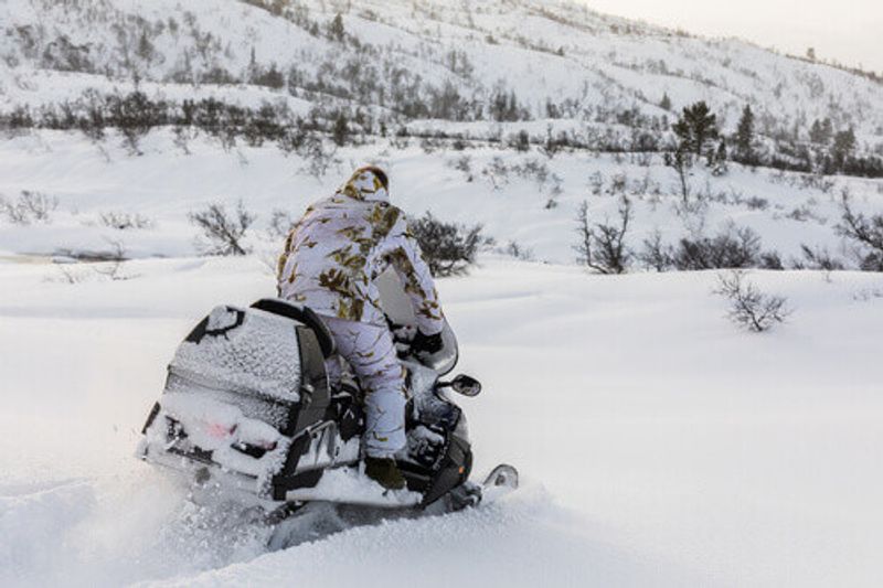 A man on a snowmobile during a safari experience.