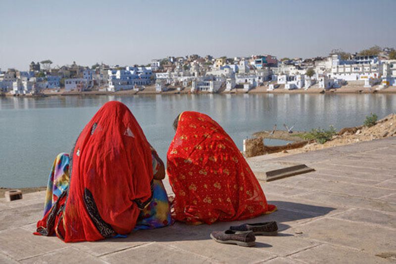 Indian women sitting on the banks of Pushkar Lake in Rajasthan.