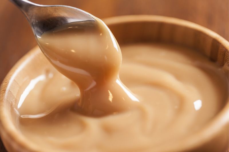 The creamy and sweet Dulce de Leche cream in a wooden bowl.