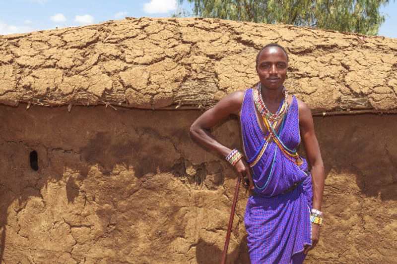 Masai man wearing traditional costume at a cultural village near the Amboseli National Park Reserve.