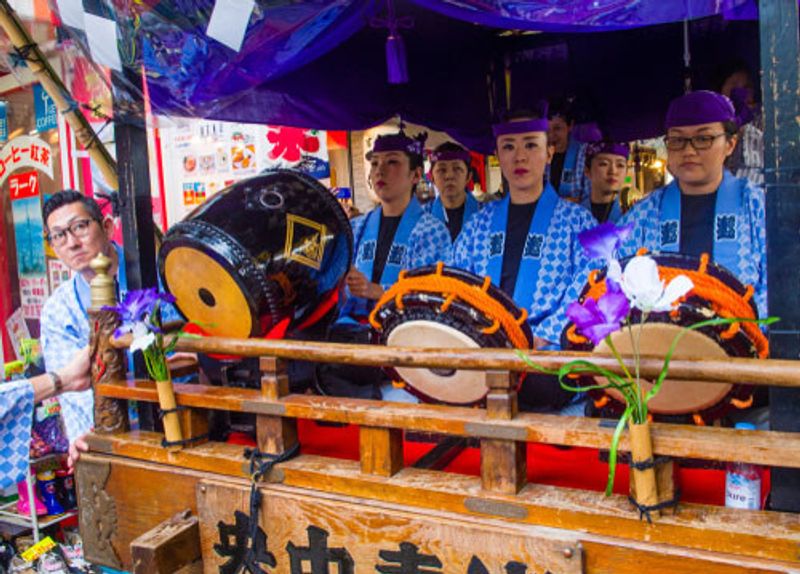 Locals dressed in traditional clothing playing drums.