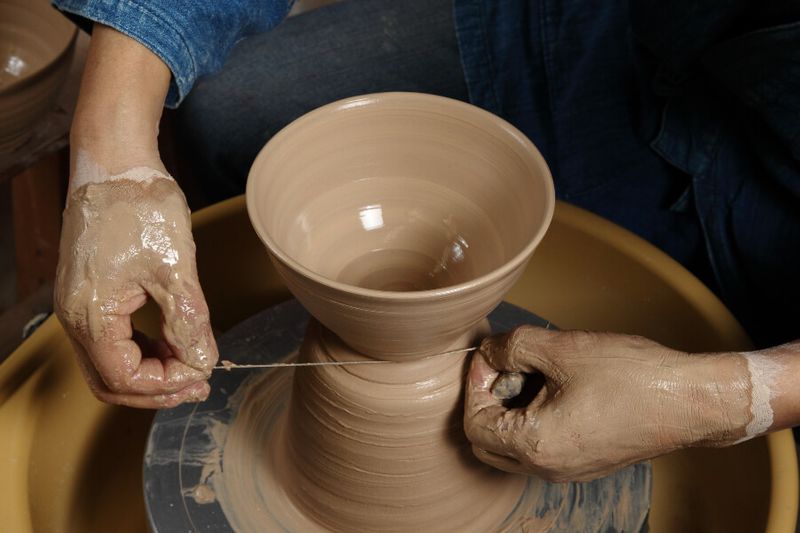 Japanese potter using a thread to shape the ceramic
