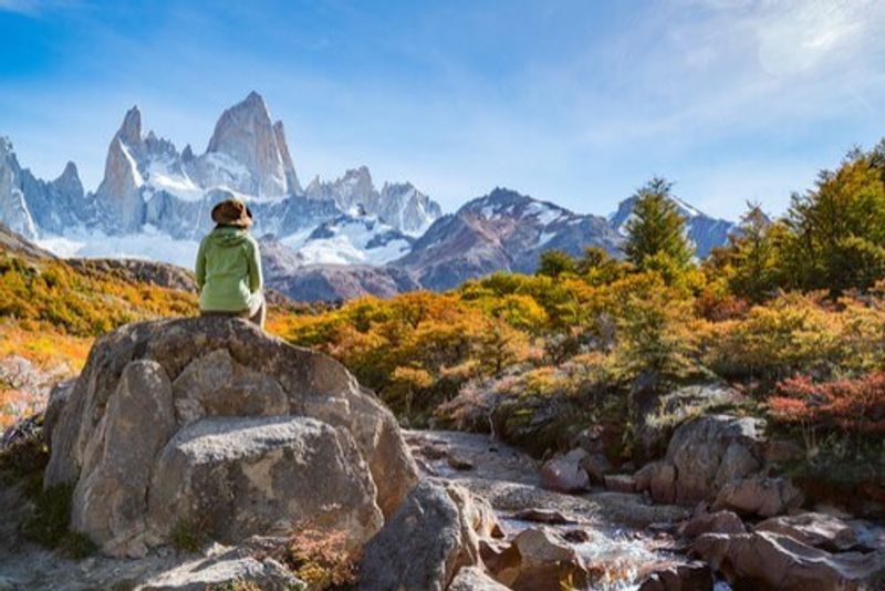 A visitor sits and takes in the mountains before her.